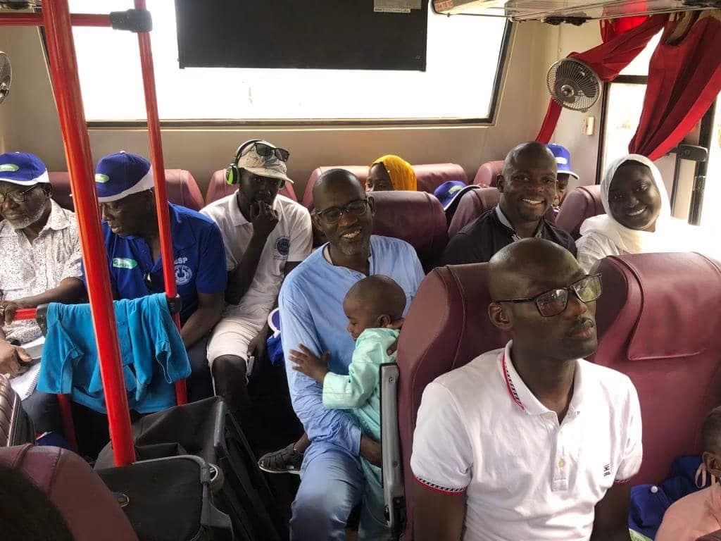 Ambiance conviviale et sourires à bord du car pendant le trajet.